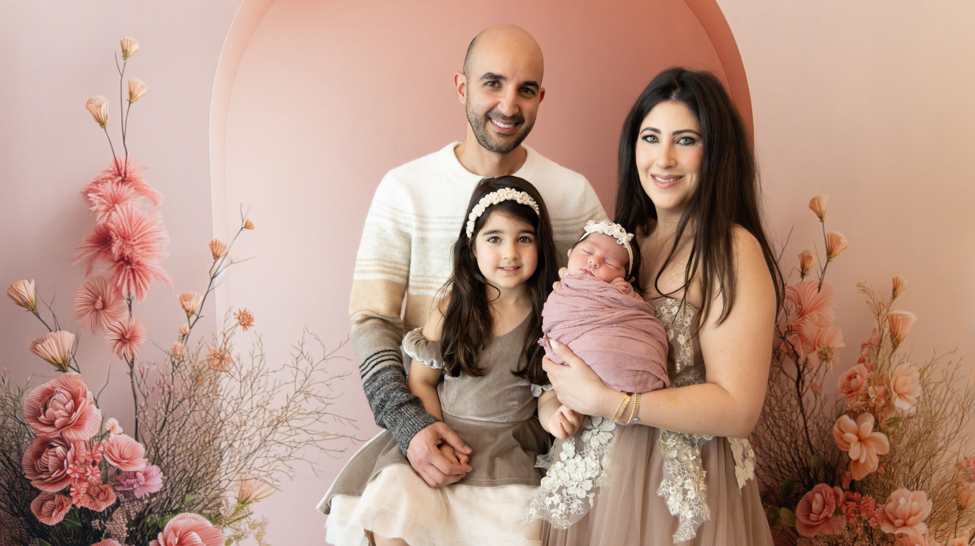 Professional photo of Jonathan beside his wife and daughters.